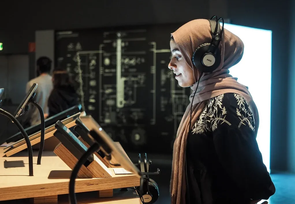 woman listening to audio guide in the museum